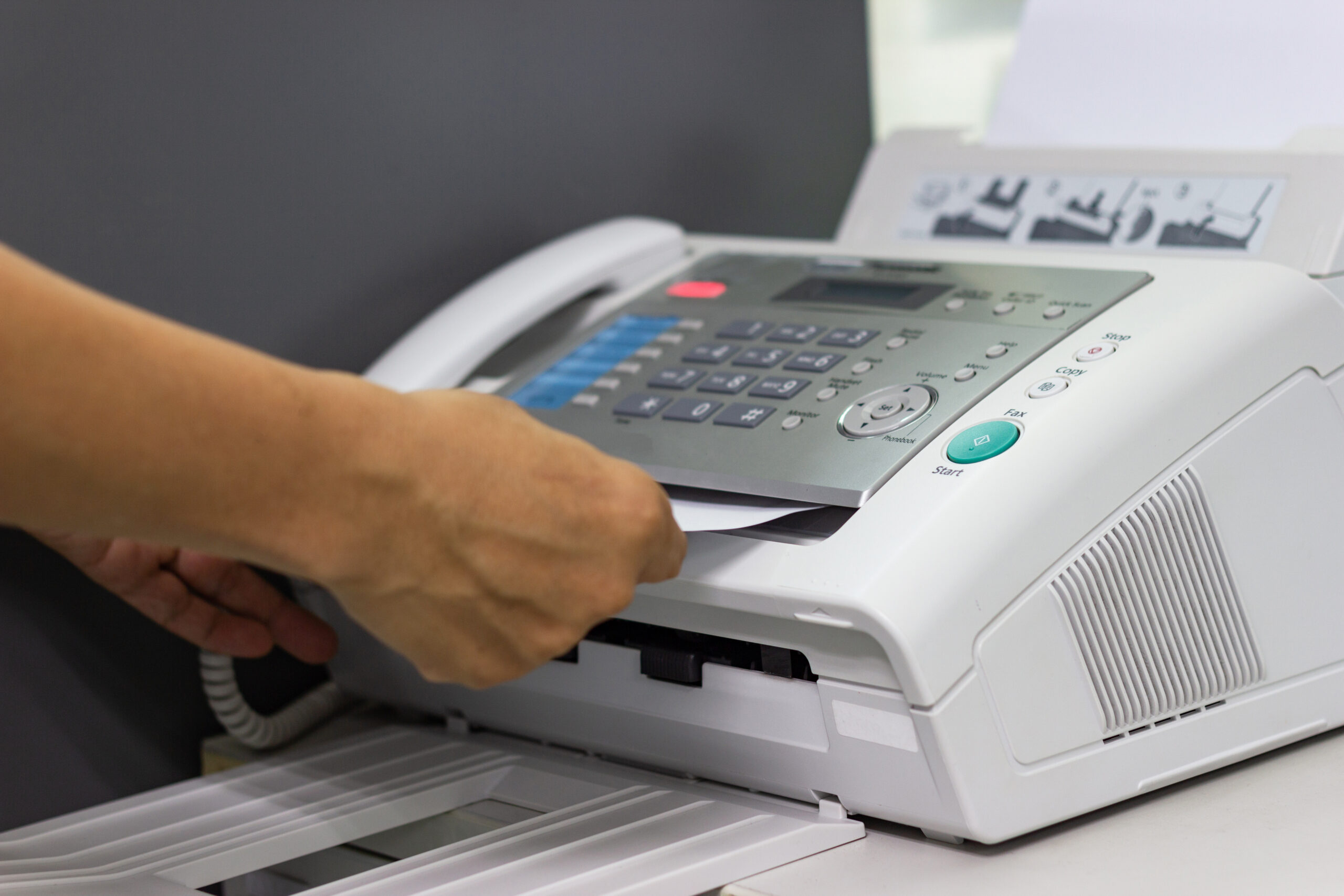 hand of man are using a fax machine in the office Business conc