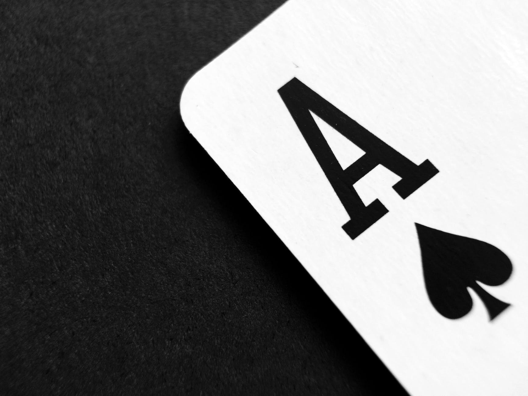 ace of spade playing card on grey surface